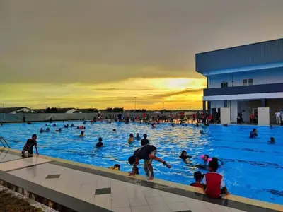 a group of people swimming in a swimming pool at CozyStayz Perak in Sitiawan