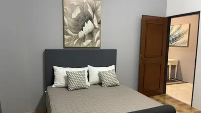 a bedroom with a bed with pillows and a painting at Homestay Rumah 25 in Sungai Petani