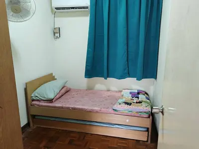 a small bed in a room with a blue curtain at Bayu Emas Batu Ferringhi 2 in Ayer Itam