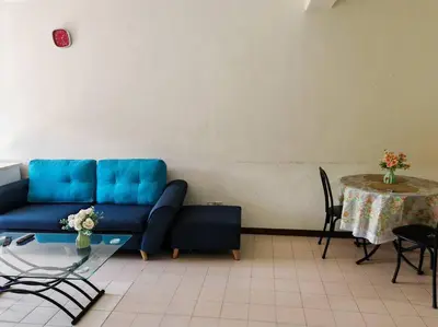 a living room with a blue couch and a table at Bayu Emas Batu Ferringhi 2 in Ayer Itam