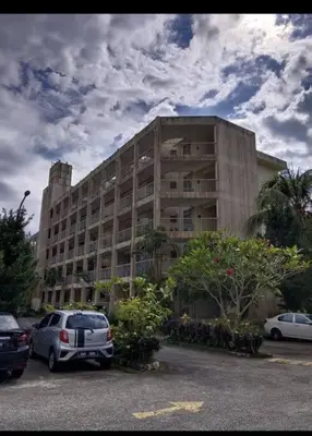 a large building with cars parked in a parking lot at Bayu Emas Batu Ferringhi 2 in Ayer Itam