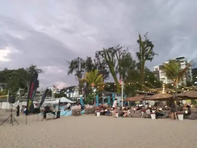 a beach with people sitting in chairs on the sand at Sri sayang pearl view in Batu Ferringhi