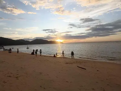 a group of people on the beach at sunset at Sri sayang pearl view in Batu Ferringhi
