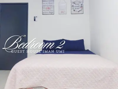 a bedroom with a bed with a guest house sign on it at Guest House Iman Umi Bagan Serai in Bagan Serai