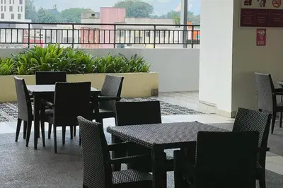 a group of tables and chairs on a balcony at JS Ipoh Homestay 2 At The Majestic Ipoh in Ipoh