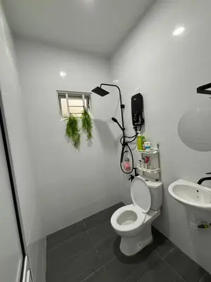 a white bathroom with a toilet and a sink at Idaman Cottage Sekinchan in Tanjung Karang