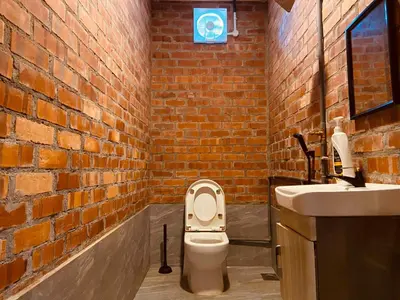 a brick bathroom with a toilet and a sink at Homestay Damai D'Sawah in Kampong Parit Fourteen