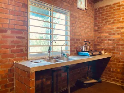 a kitchen with a sink and a brick wall at Homestay Damai D'Sawah in Kampong Parit Fourteen