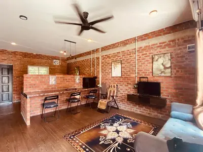 a living room with a ceiling fan and a brick wall at Homestay Damai D'Sawah in Kampong Parit Fourteen
