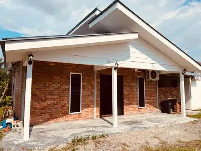 a brick house with a white roof at Homestay Damai D'Sawah in Kampong Parit Fourteen