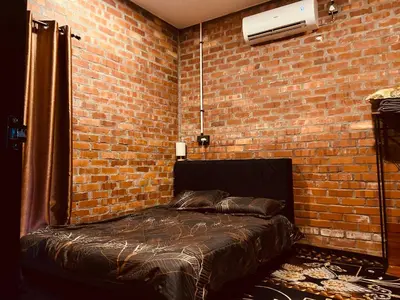 a bedroom with a bed in a brick wall at Homestay Damai D'Sawah in Kampong Parit Fourteen