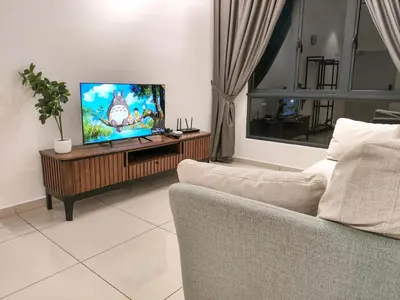 a living room with a couch and a flat screen tv at The Horizon Ipoh by 40 Winks in Ipoh