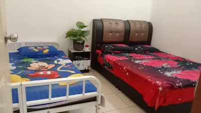 a bedroom with a bed with a mickey mouse bedspread at Sinakhan Homestay in Gua Musang