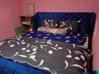 a bedroom with a blue bed with a black and white blanket at Sinakhan Homestay in Gua Musang