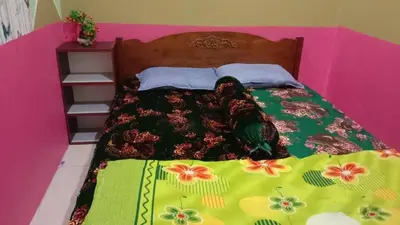 a bed with a colorful comforter on top of it at Sinakhan Homestay in Gua Musang