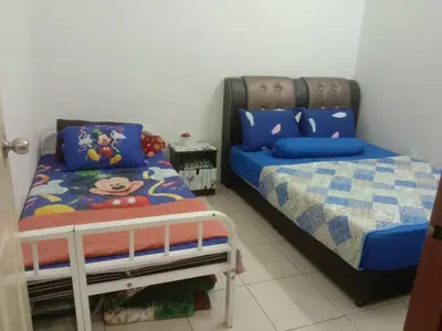 a bedroom with a twin bed and a crib at Sinakhan Homestay in Gua Musang