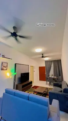 a living room with a blue couch and a ceiling fan at Hidden Plan Homestay in Kepala Batas