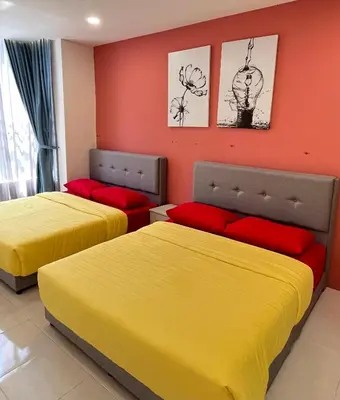 two beds in a room with yellow and red at FY Friends at Emerald Avenue Brinchang in Tanah Rata