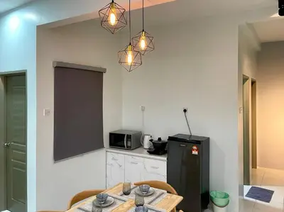 a kitchen with a table and a black refrigerator at Space of Tranquility Quintet in Tanah Rata