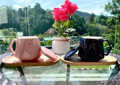 two cups and a vase with a flower on a table at Space of Tranquility Quintet in Tanah Rata
