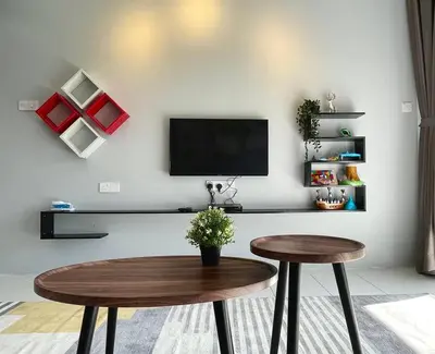 a living room with a table and a tv on a wall at Space of Tranquility Quintet in Tanah Rata
