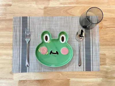 a green plate with a face on it sitting on a table at Removed listing in Tanah Rata