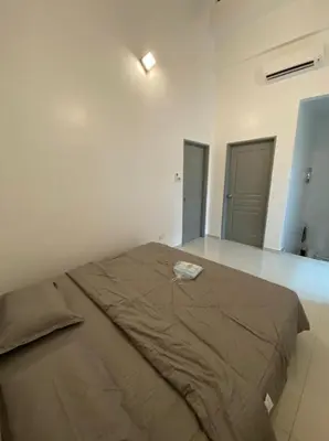 a bedroom with a large bed in a white room at PANGKOR Villa 88 L26 Homestay in Kampong Sungai Udang