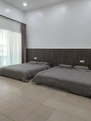 two beds in a large bedroom with a wall at PANGKOR Villa 88 L26 Homestay in Kampong Sungai Udang