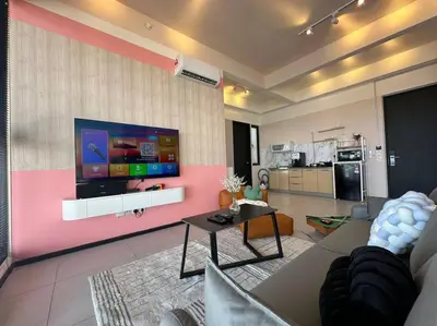 a living room with a flat screen tv on a wall at Perfect KTV Set & Netflix 3 Queen Bed Seaview in Jelutong