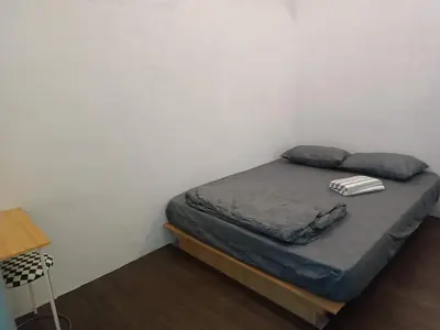 a small bedroom with a bed in a white wall at Jstay guesthouse in George Town