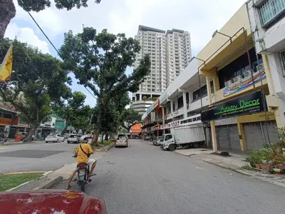 a person riding a bike down a city street at Jstay guesthouse in George Town