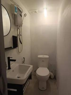 a bathroom with a white toilet and a sink at Jstay guesthouse in George Town