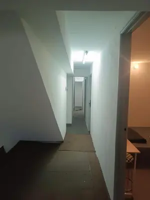 a hallway with white walls and a hallway with a light at Jstay guesthouse in George Town