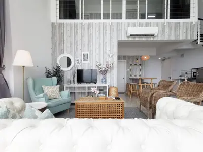 a living room with a white couch and chairs at Fascinating Seaview Apartment at Maritime Penang in Jelutong