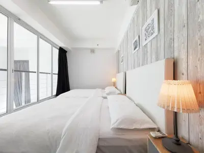 a white bedroom with a large bed and a lamp at Fascinating Seaview Apartment at Maritime Penang in Jelutong
