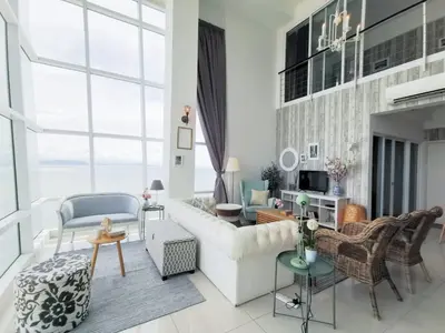 a living room with a white couch and chairs at Fascinating Seaview Apartment at Maritime Penang in Jelutong