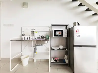 a small kitchen with a refrigerator and a table at Fascinating Seaview Apartment at Maritime Penang in Jelutong