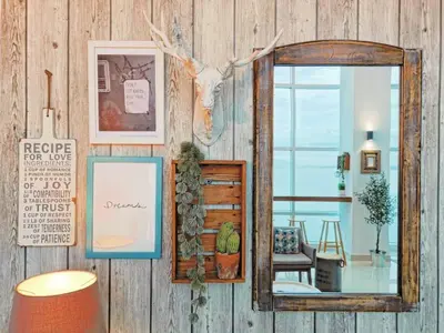 a mirror on a wall with pictures and a room at Fascinating Seaview Apartment at Maritime Penang in Jelutong