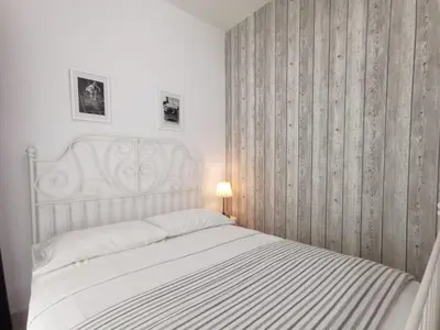a bedroom with a white bed with a striped blanket at Fascinating Seaview Apartment at Maritime Penang in Jelutong