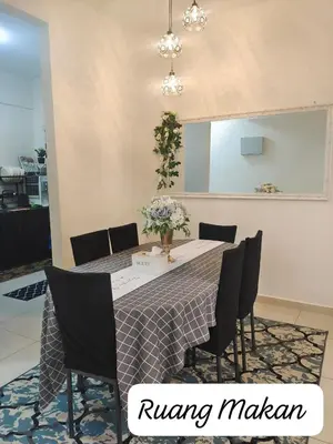 a dining room table with chairs and a vase of flowers on it at Meeymohd Homestay in Ipoh