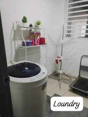 a laundry room with a trash can and a chair at Meeymohd Homestay in Ipoh