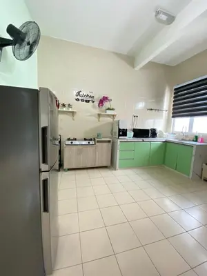 a kitchen with green cabinets and a refrigerator at Deandra Homestay- WiFi-Aircond-Dryer in Sungai Petani