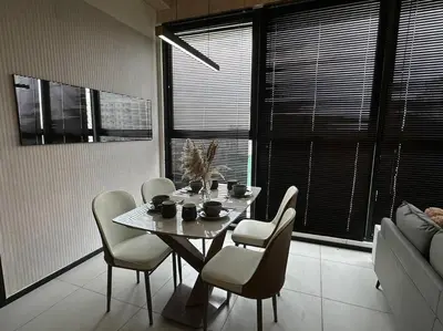 a dining room table with chairs and a cat sitting on it at High Floor, 3BR 3queen bed, 2 parking, Urban Suites by XWHome in Jelutong