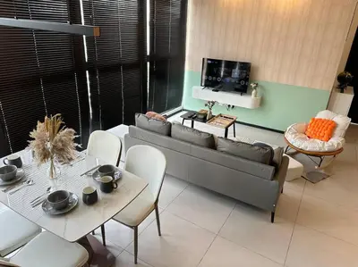 a living room with a couch and a table and chairs at High Floor, 3BR 3queen bed, 2 parking, Urban Suites by XWHome in Jelutong