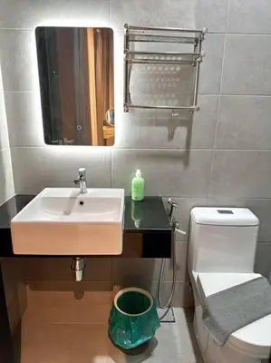 a bathroom with a sink and a toilet and a mirror at URBAN Suites Modern Pinky 6pax 3queen 3Bedroom 2Bathroom 2Carpark with Infinity Pool in Jelutong