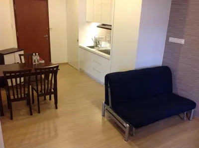 a living room with a chair and a table at WenCozy 118 Vacation Home in George Town