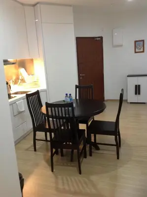 a dining room with a table and chairs and a kitchen at WenCozy 118 Vacation Home in George Town
