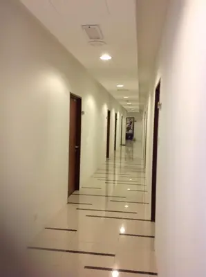 an empty hallway of a building with doors and tile floors at WenCozy 118 Vacation Home in George Town