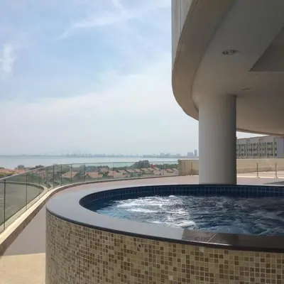 a hot tub on the balcony of a building at WenCozy 118 Vacation Home in George Town
