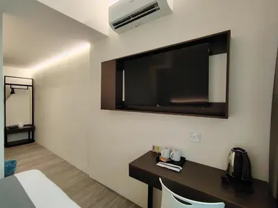 a hotel room with a television on the wall at The great hotel greenhill in Ipoh